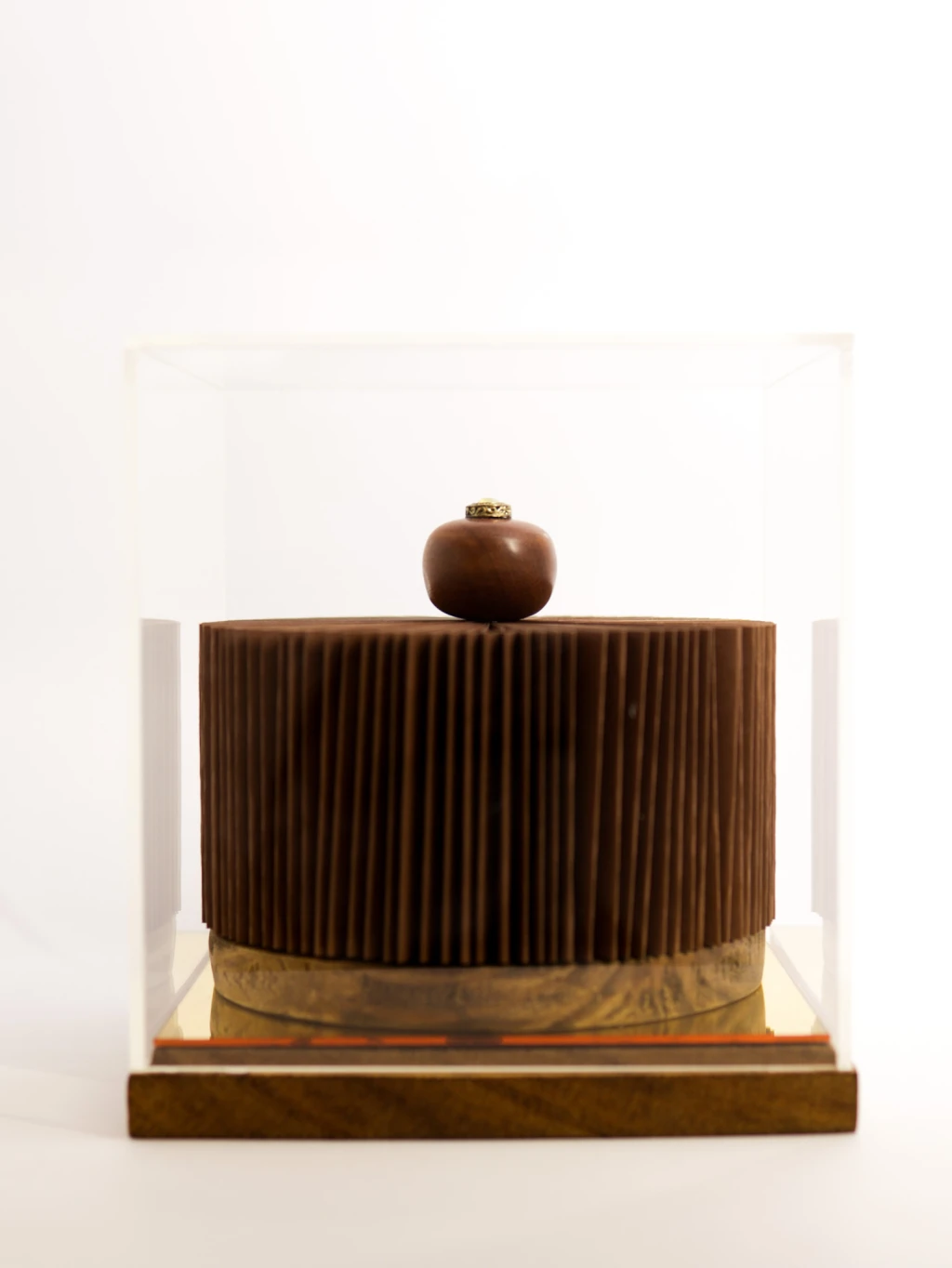 Escultura marrom cilíndrica com tampo em madeira.