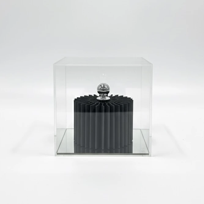 Escultura de papel verde cilindrica com bola prateada e base espelho